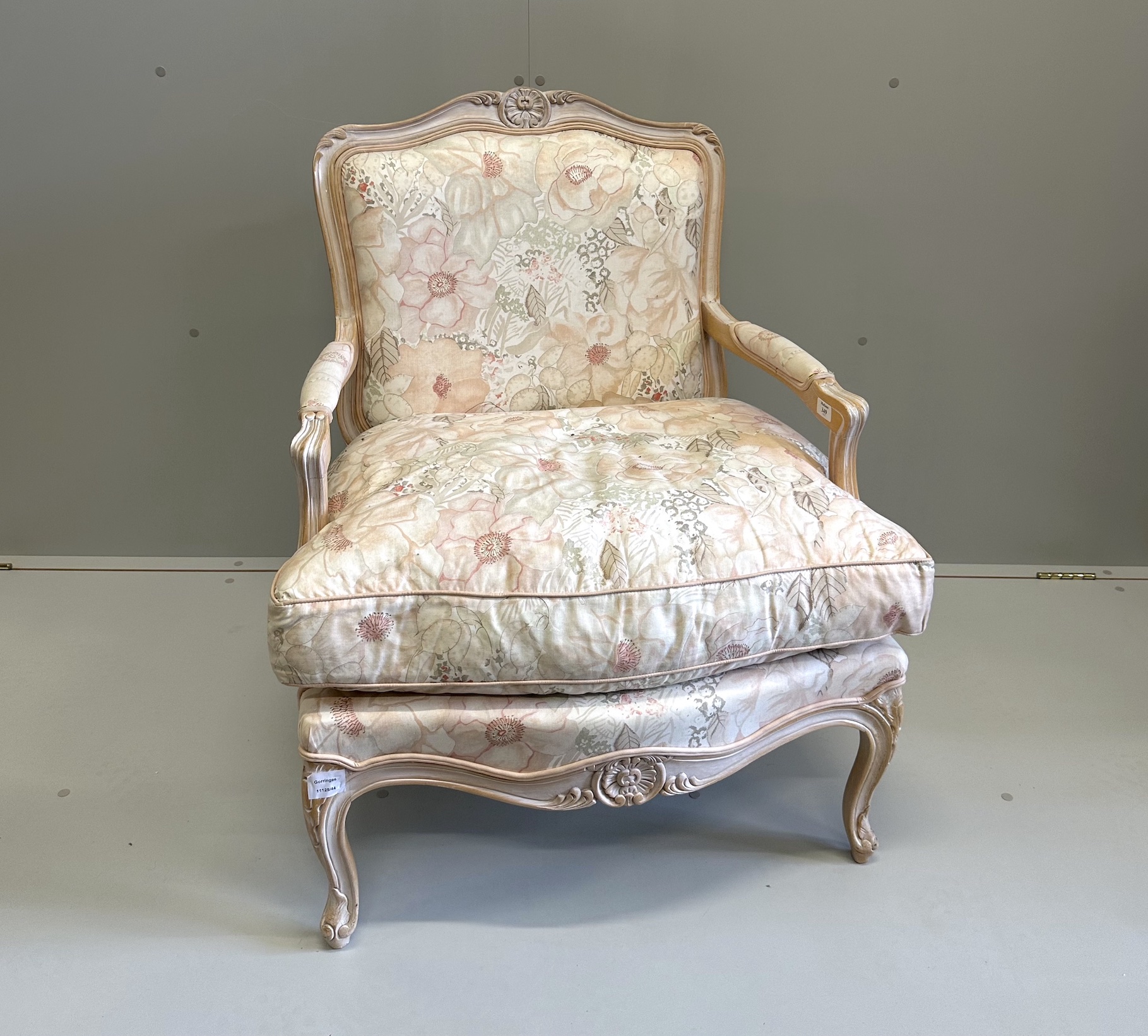 A Louis XV style bleached framed fauteuil, with floral upholstery and feather filled cushion seat, width 70cm, depth 60cm, height 89cm